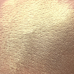 Eye shadow gold pigment swatch on skin, showing texture and shimmer