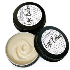 Eye balm in black metal containers with white labels and cream balm inside, KAROMNICO brand visible