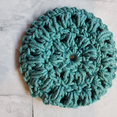 Crochet coaster teal yarn round shape on white surface