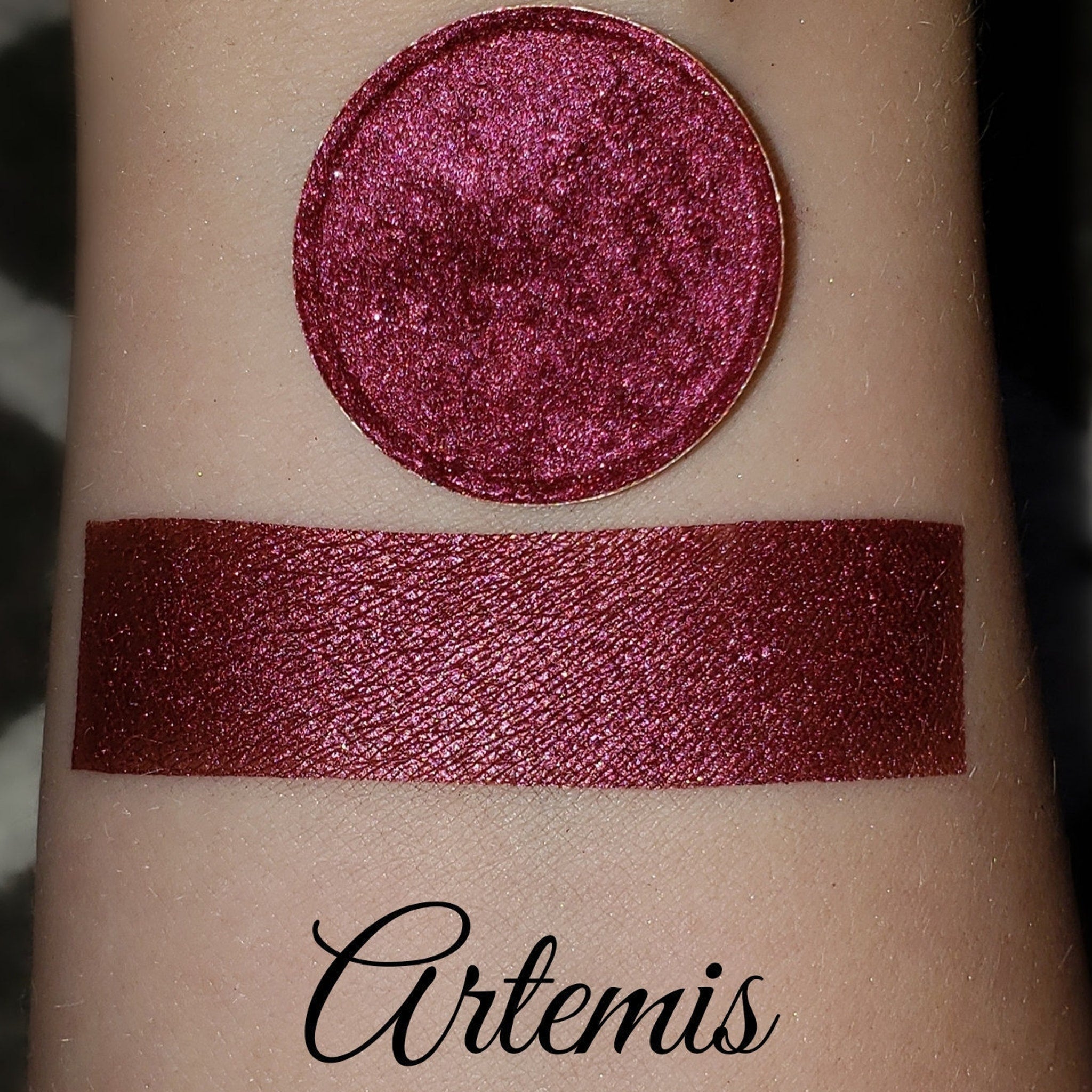 Eyeshadow swatch with shimmer, burgundy color, and Artemis brand name