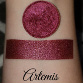 Eyeshadow swatch with shimmer, burgundy color, and Artemis brand name