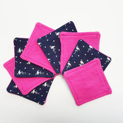 Square fabric coasters in pink and navy with flamingo pattern, stacked on white surface