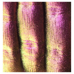 Iridescent textured material with pink, yellow, and brown color variations and vertical lines