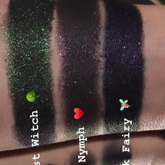 Eye shadow swatches with green, pink, and purple glitter on skin, Smudg'D Dark Trio