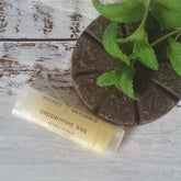 Lip balm tube with "Wicked Naturals" label, light yellow balm, brown chocolate disc, and green mint leaves