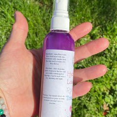 Rose Toner spray bottle with purple liquid, white label, and white spray top held in hand