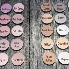 Eyeshadow palette with various colors, round compacts, and brand names visible