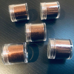 Close-up of matte black eye shadow in round compact with smooth, velvety texture and minimalist packaging