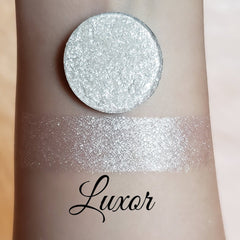Eyeshadow shimmer pigment, silver pressed powder and swatch on skin, Luxor brand visible