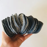 Makeup remover pads, gray and white cotton rounds, held in hand