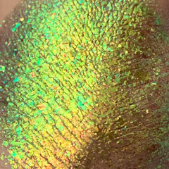 Green iridescent glitter flakes with yellow and green hues, textured appearance