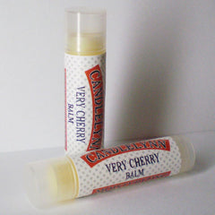 Lip balm tubes with white polka dot pattern, red text, and Candle Lynn brand name visible