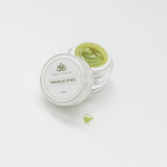 Miracle Eyes cream jar with green cream and Body + Soul label on white surface