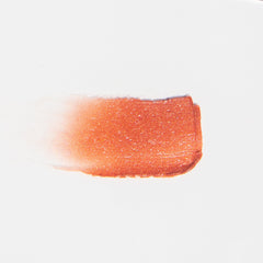 Lip gloss swatch, orange-red shimmer, glossy texture, on white background