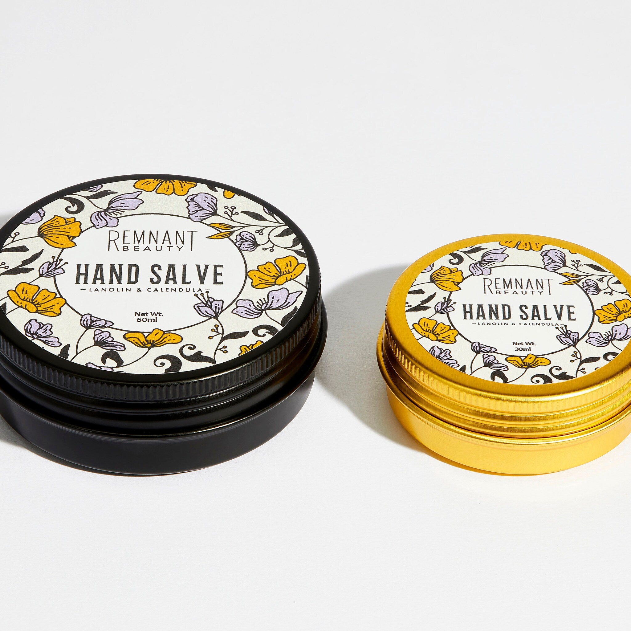 Hand cream black and gold metal tins with floral pattern, Remnant Beauty branding