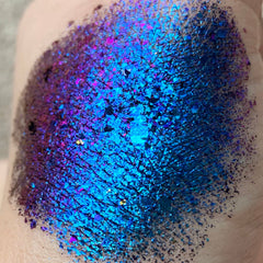 Hand applying Tala Foil Thunderstorm Eye Shadow Pigment in shimmering silver-blue shade with fingertip