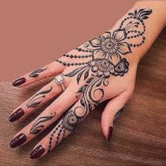 Elegant hand applying natural brown henna tattoo in intricate mehndi design on wrist