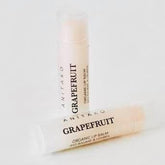 Lip balm tubes with white and beige labels, ANITAKO GRAPEFRUIT text visible