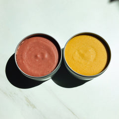 Cosmetic cream in metal tins, red and yellow colors, smooth texture, top view