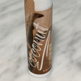 Coconut lip balm tube with brown and white label, "Coconut" script, Windrift Hill brand