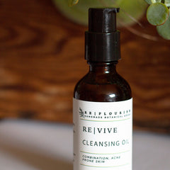 Cleansing oil bottle, brown glass, black pump, REVIVE label visible