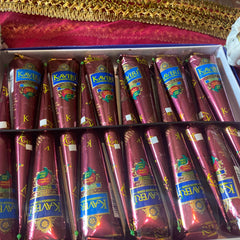 Close-up of natural brown henna cone with smooth texture and earthy tone, resting on wooden surface