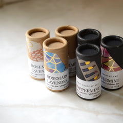 Lip balm tubes in various colors with patterned labels and cardboard material