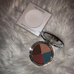 Quad eyeshadow palette with silver metal case and four color eyeshadows on white fur background