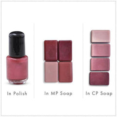 Nail polish bottle with black cap and pink liquid, next to pink soap bars in rows