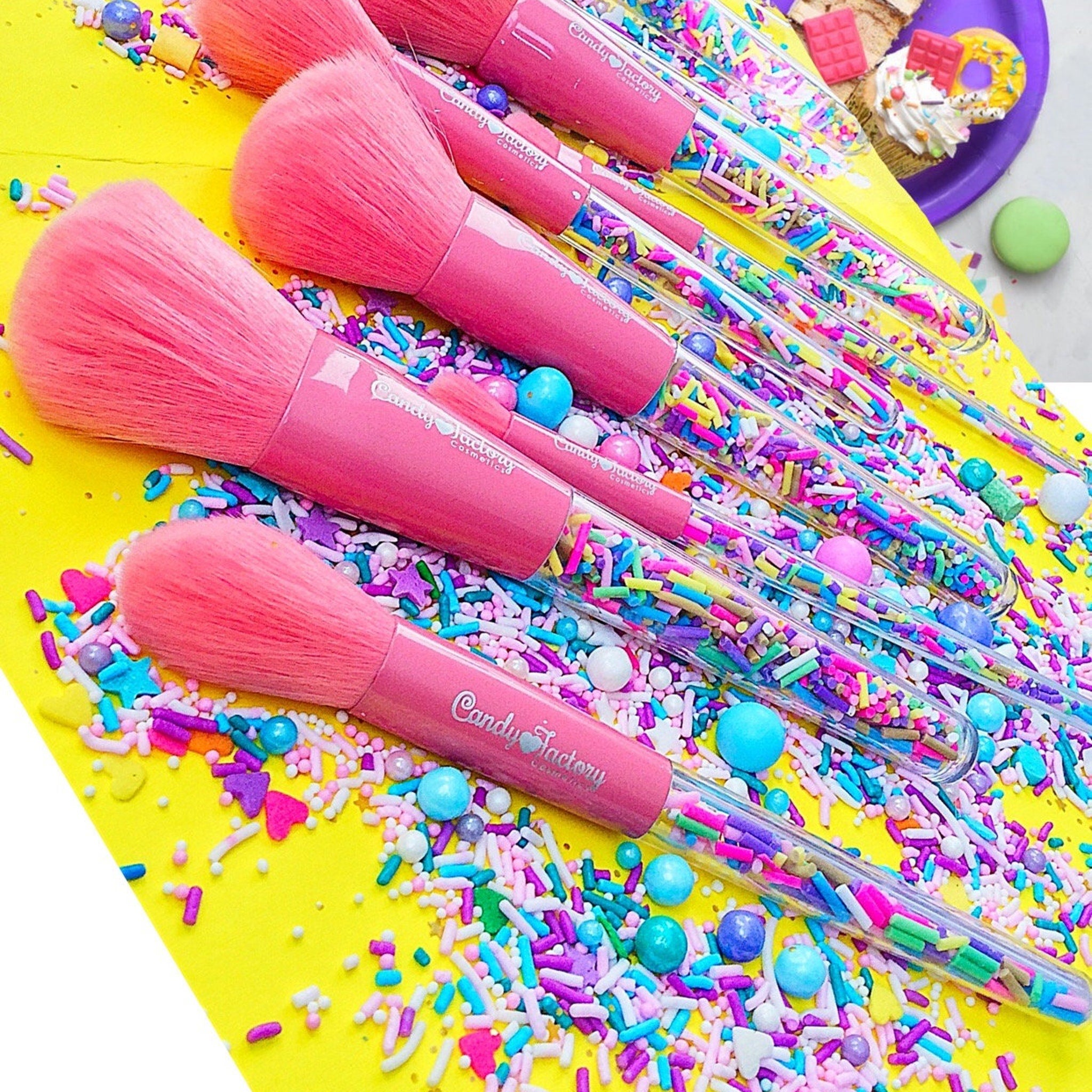 Set of three pastel-colored eyeshadow brushes with pink, blue, and purple handles and soft synthetic bristles