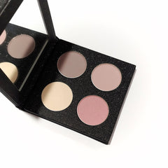 Close-up of four rosy-toned matte eyeshadows in a sleek refillable palette with embossed logo