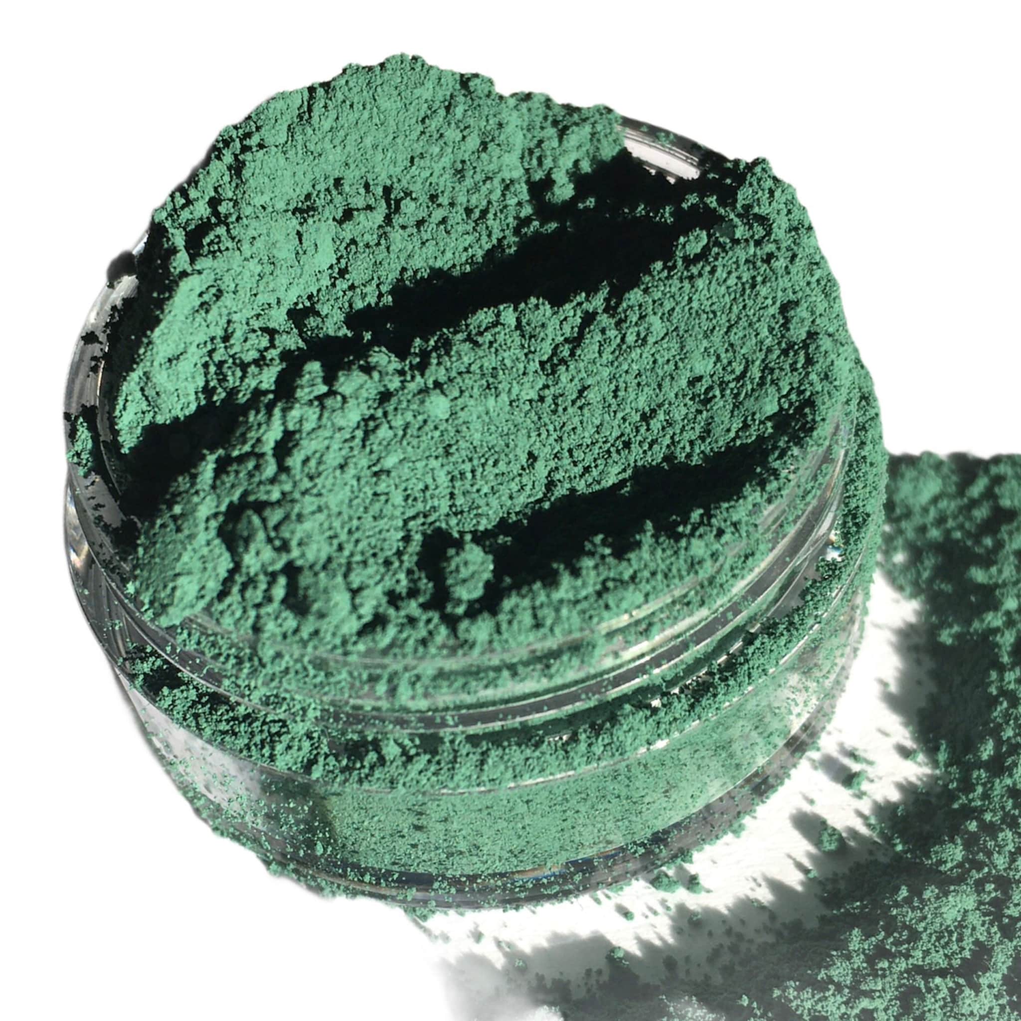 Eyeshadow powder, matte forest green color in clear jar, loose pigment visible