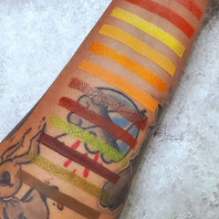 Side view of Autumn Splendor eyeshadow palette showing six vegan shades in yellow, orange, red, green, and brown