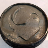 Black glass jar of activated charcoal and turmeric face mask with gold lid and minimalist label