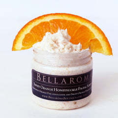 Facial scrub jar with white cream, orange slice, and BellaRoma label on white background