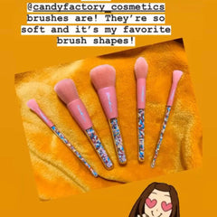 Hand holding a sprinkle eyeshadow brush applying shimmer powder to eyelid