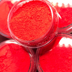 Side view of vibrant red eyeshadow pigment pot showing rich matte texture and compact size