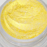Close-up of loose mica eyeshadow powder in bright sunshine yellow with shimmer particles