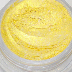 Close-up of loose mica eyeshadow powder in bright sunshine yellow with shimmer particles