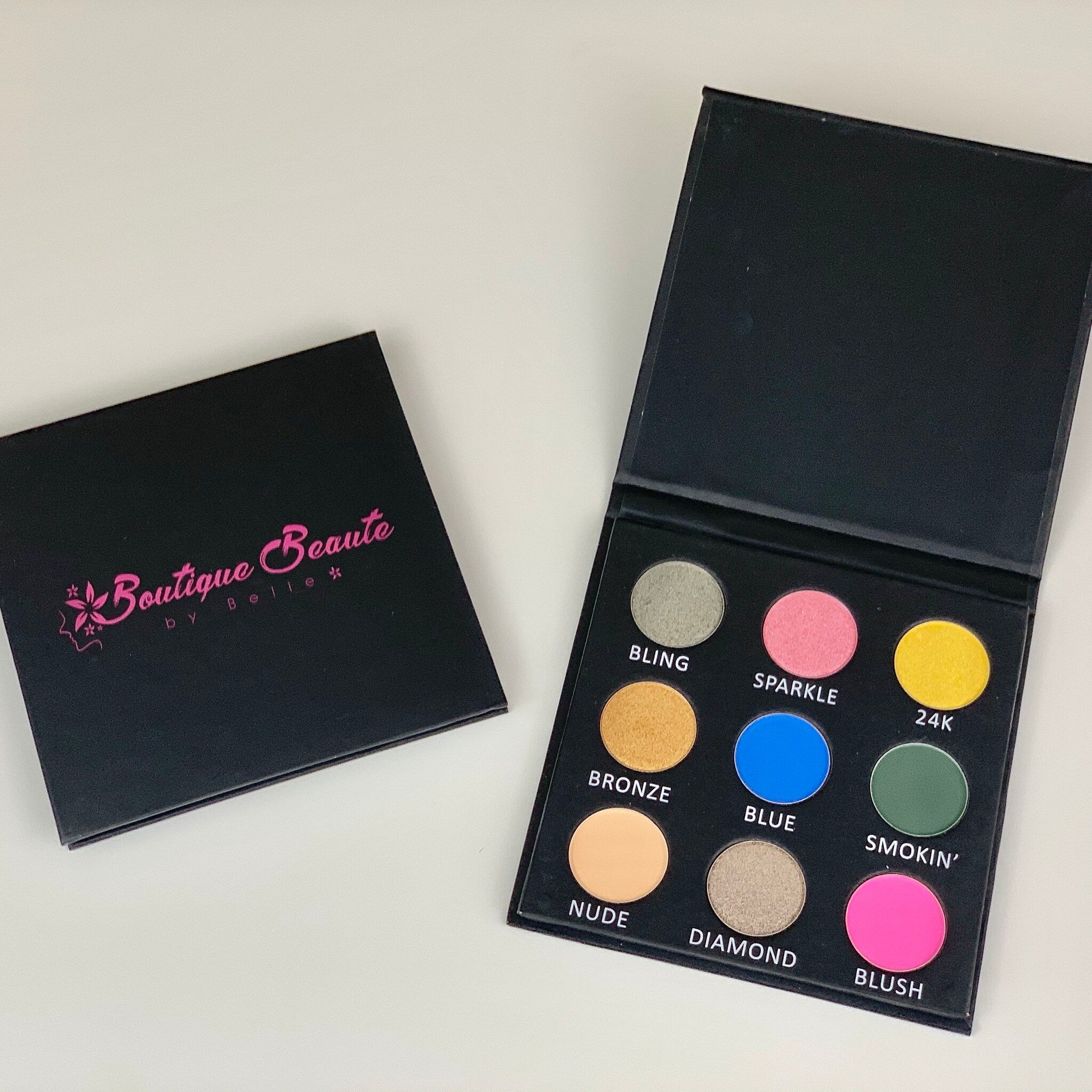 Open rectangular palette displaying nine vibrant eyeshadow shades in matte and shimmer finishes with a mirror