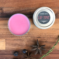 Lip tint in pink color, silver metal tin, Herbs Soil Apothecary brand label on top