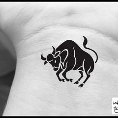 Close-up of Taurus zodiac temporary tattoo on skin, showcasing intricate astrological design with metallic sheen