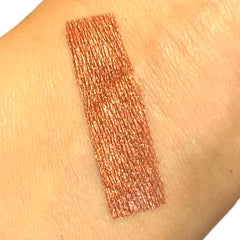 Eyeshadow swatch, bronze metallic, textured finish, applied on skin