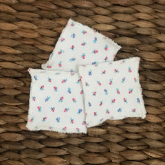 Reusable facial rounds, white cotton with pink and blue floral pattern, frayed edges