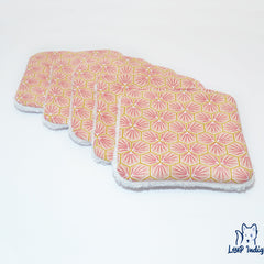 Reusable face pads with pink geometric pattern, white trim, and Loup Indig logo