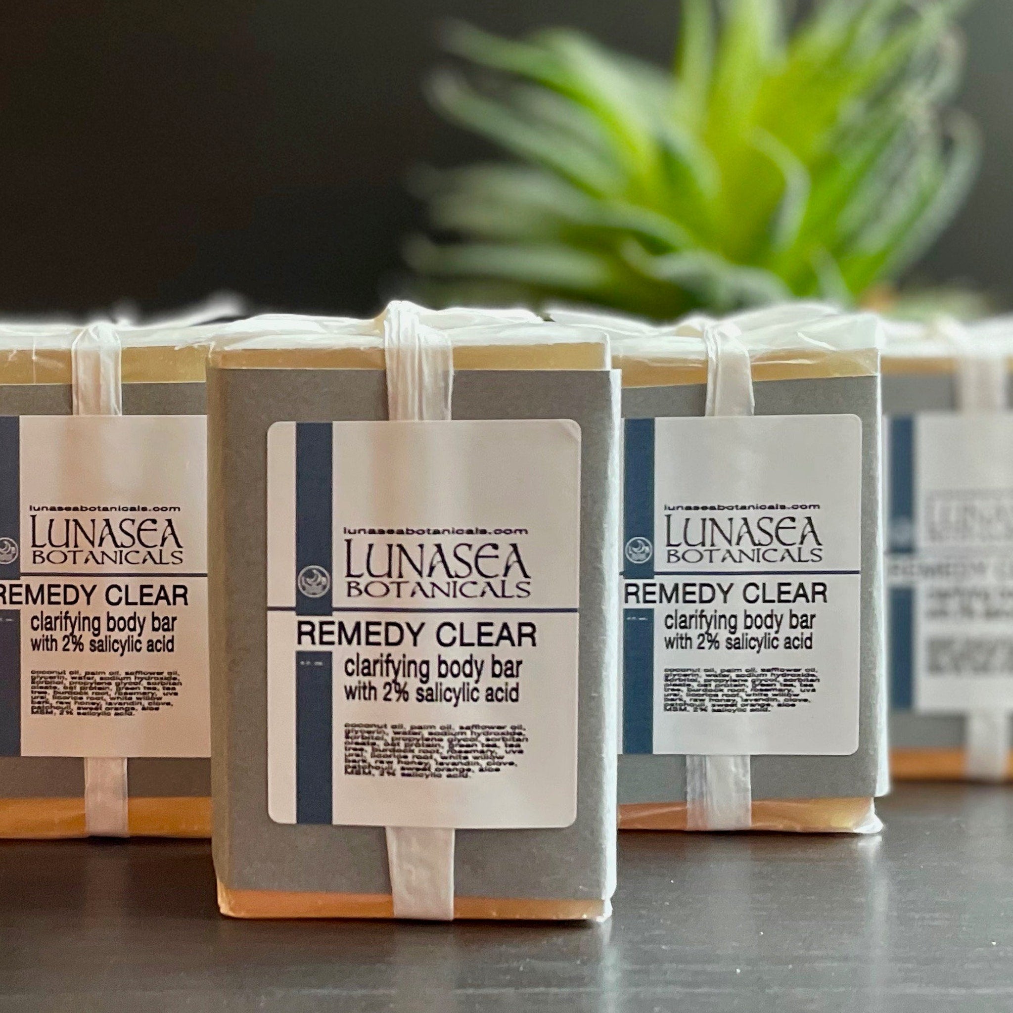 Skin care clarifying body bars wrapped in clear plastic, Remedy Clear label visible