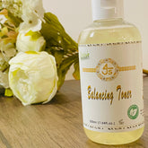 Toner bottle with white label, clear liquid, and 4Js Natural branding