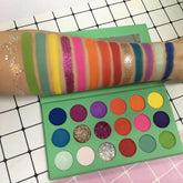 Eye shadow palette with green, pink, and glitter shades, shown on arm and in palette form