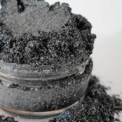 Side view of silver shimmer eye shadow in sifter jar showing mineral texture and glitter particles