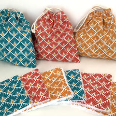 Stack of reusable bamboo makeup remover wipes with natural fiber texture on wooden surface